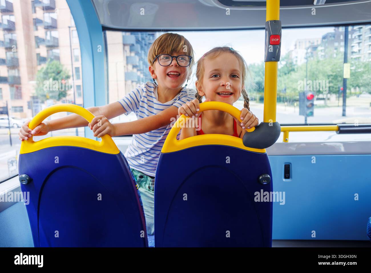 Child Bus Ride Two children happily enjoying a bus ride through summer city Stock ...