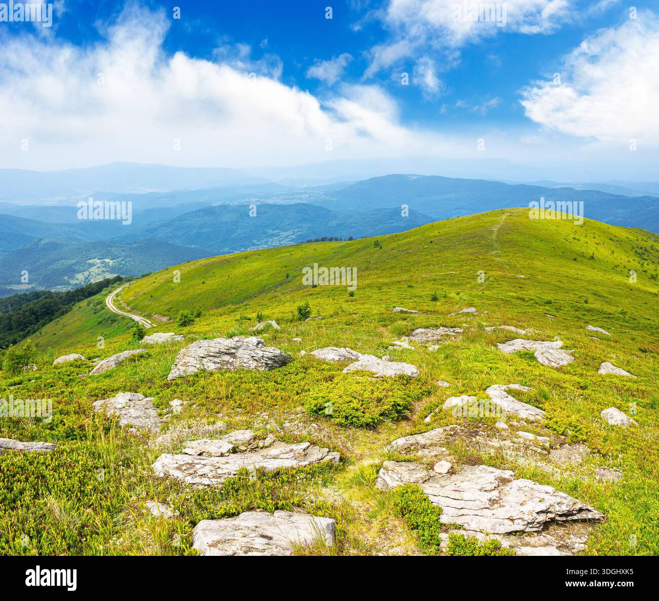mountain landscape in summer with rocks. green grass under blue sky. alpine meadow and rolling hills with boulders on sunny day. environment sustainab Stock Photo