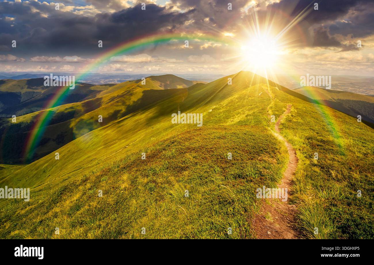 path through the grassy mountain ridge at sunset. beautiful summer landscape in fine weather with cloudy sky over green alpine meadow in evening light Stock Photo