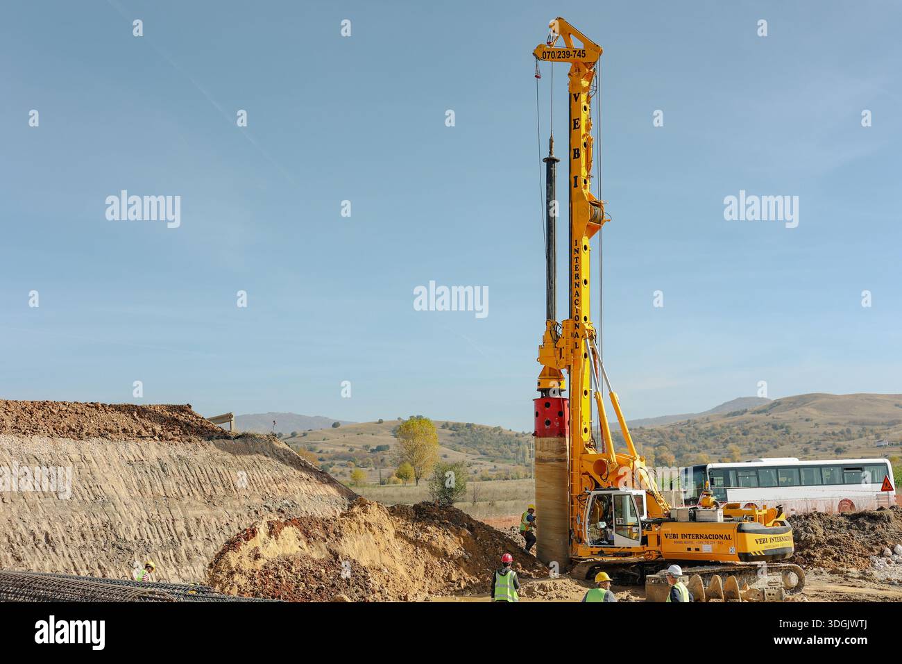 Pile driving rig operating at infrastructure construction site with ...