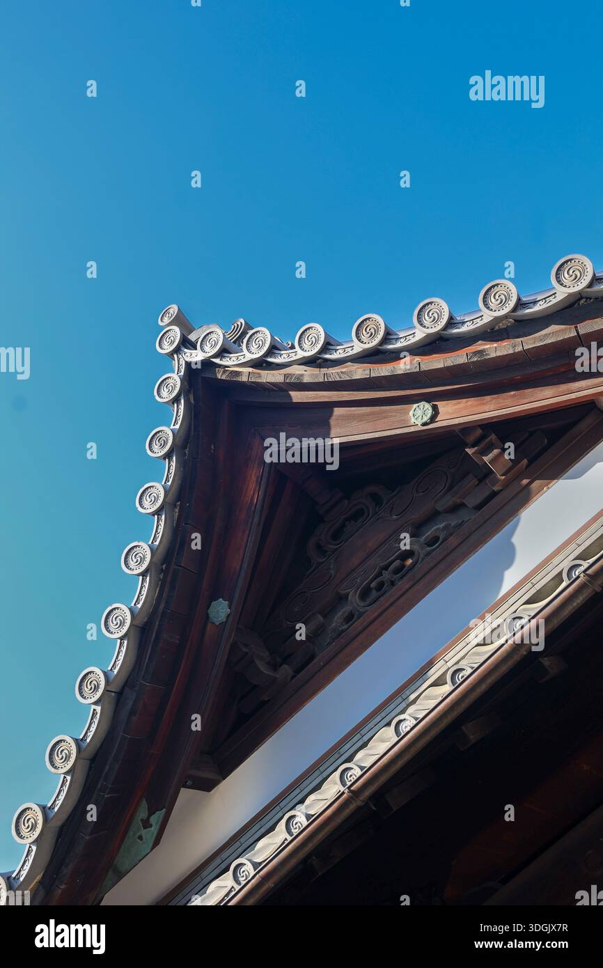 Traditional Japanese temple roof detail against clear blue sky Stock Photo