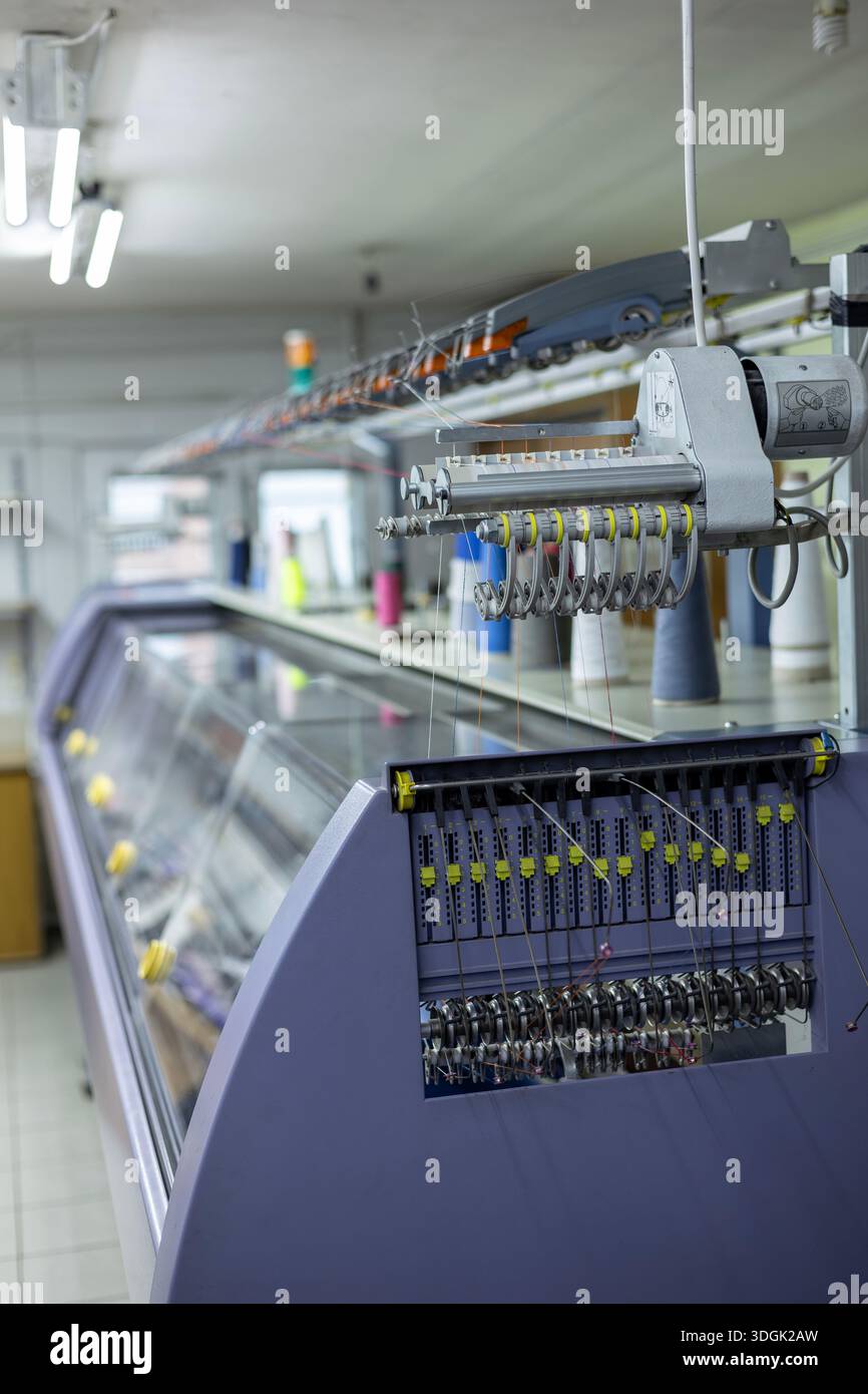 A side view of a large, automated industrial knitting machine in a ...