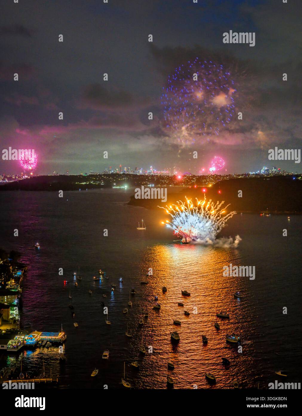 NYE FW 2026 Manly cove start vert midnight fireworks reflecting in waters of Sydney Harbour. Stock Photo