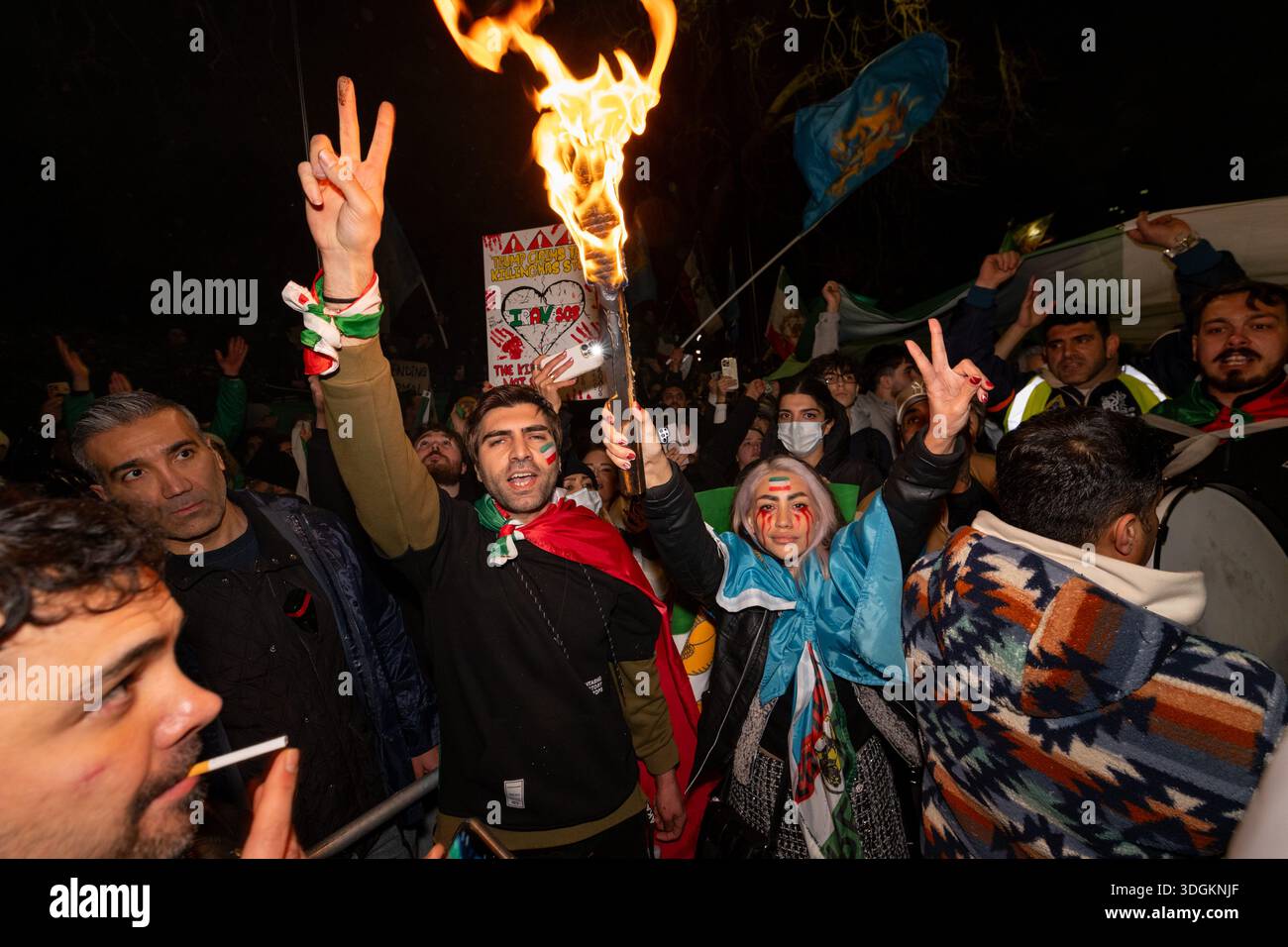 Protesters posing after setting on fire images of Iran's Supreme Leader ...