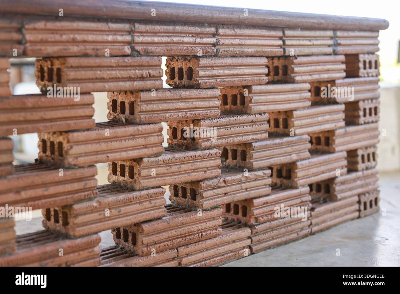 Unique brown brick wall construction featuring hollow rectangular pattern and strong solid structure with textured surface outdoors conveying stabilit Stock Photo