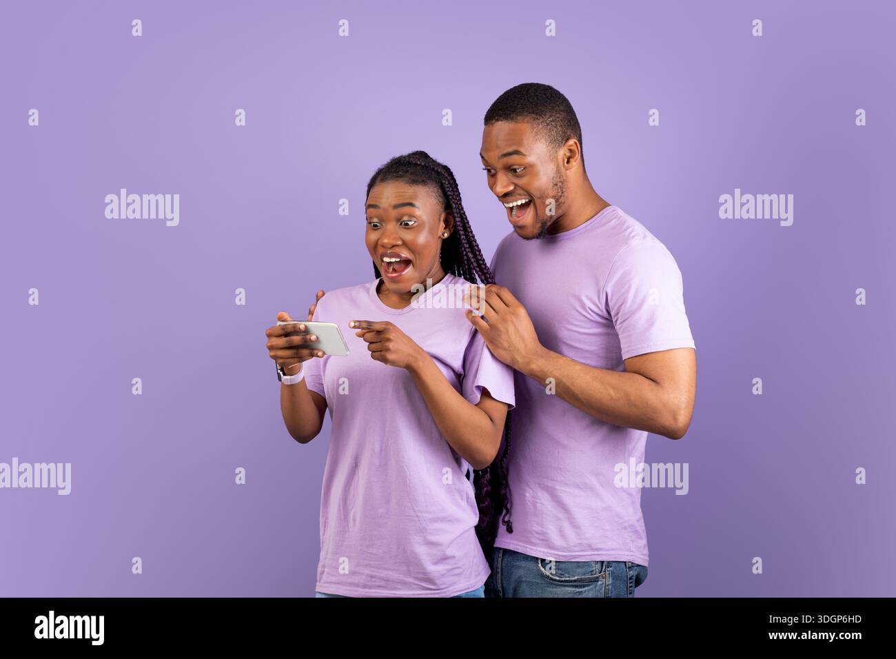 Portrait of surprised black couple using smartphone Stock Photo