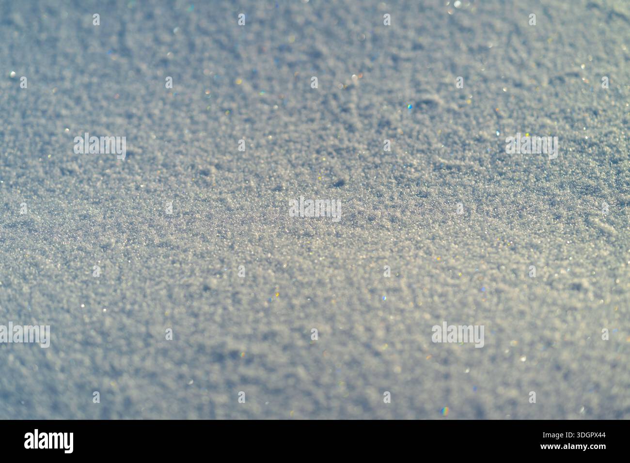 glittering snow texture under bright sun, multicolored light refractions across fine crystalline field, soft horizon blur, versatile backdrop for holi Stock Photo