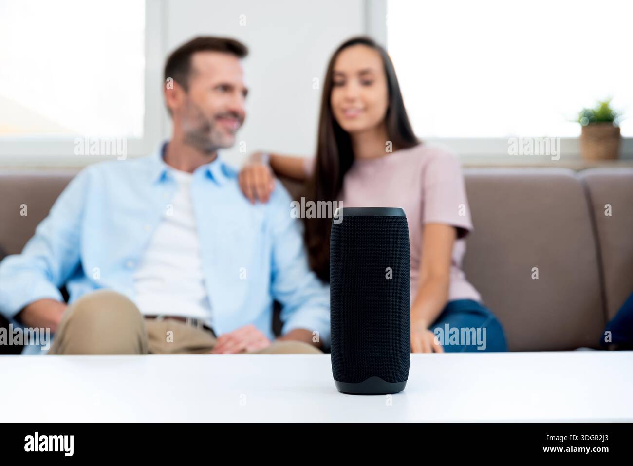 Couple using smart speaker, smart home system appliance, modern assistant || Model released Stock Photo