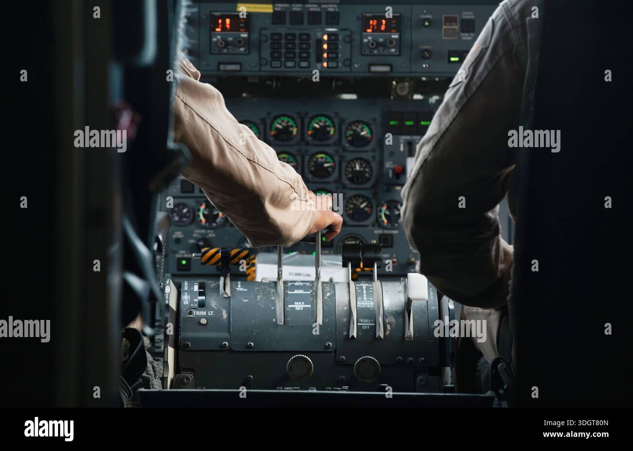 Pilot's hands adjusting throttle levers in the cockpit of an aircraft ...