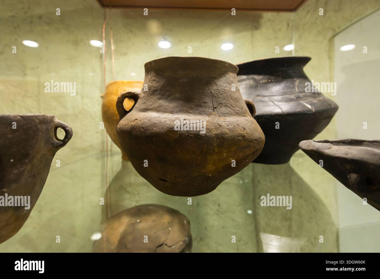 Ancient earthenware pots in museum display, showing historical artifact ...