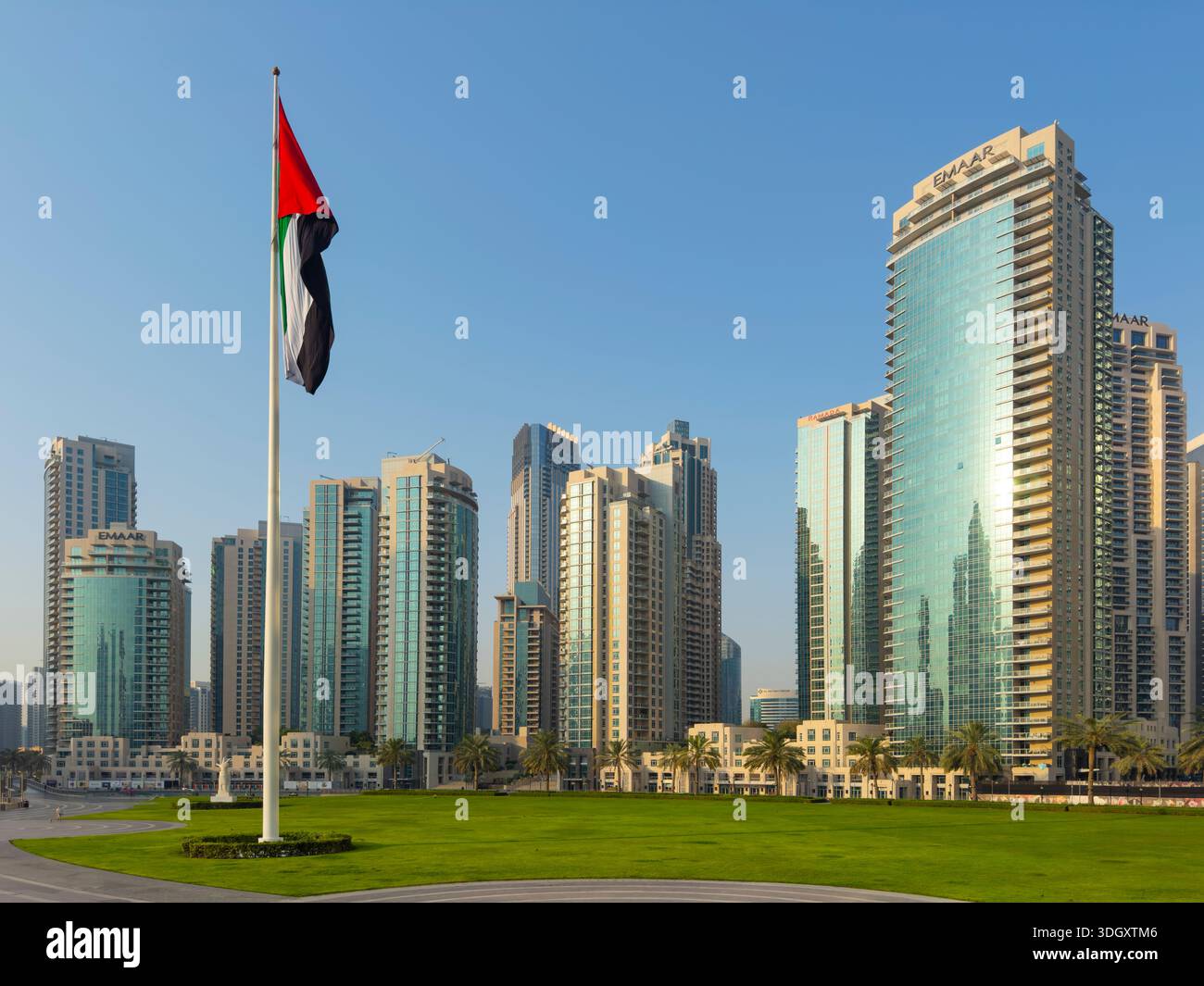 UAE National Flag at Burj Park with Modern high-rise apartment building by Emaar in Burj Khalifa district, downtown Dubai, UAE. Stock Photo