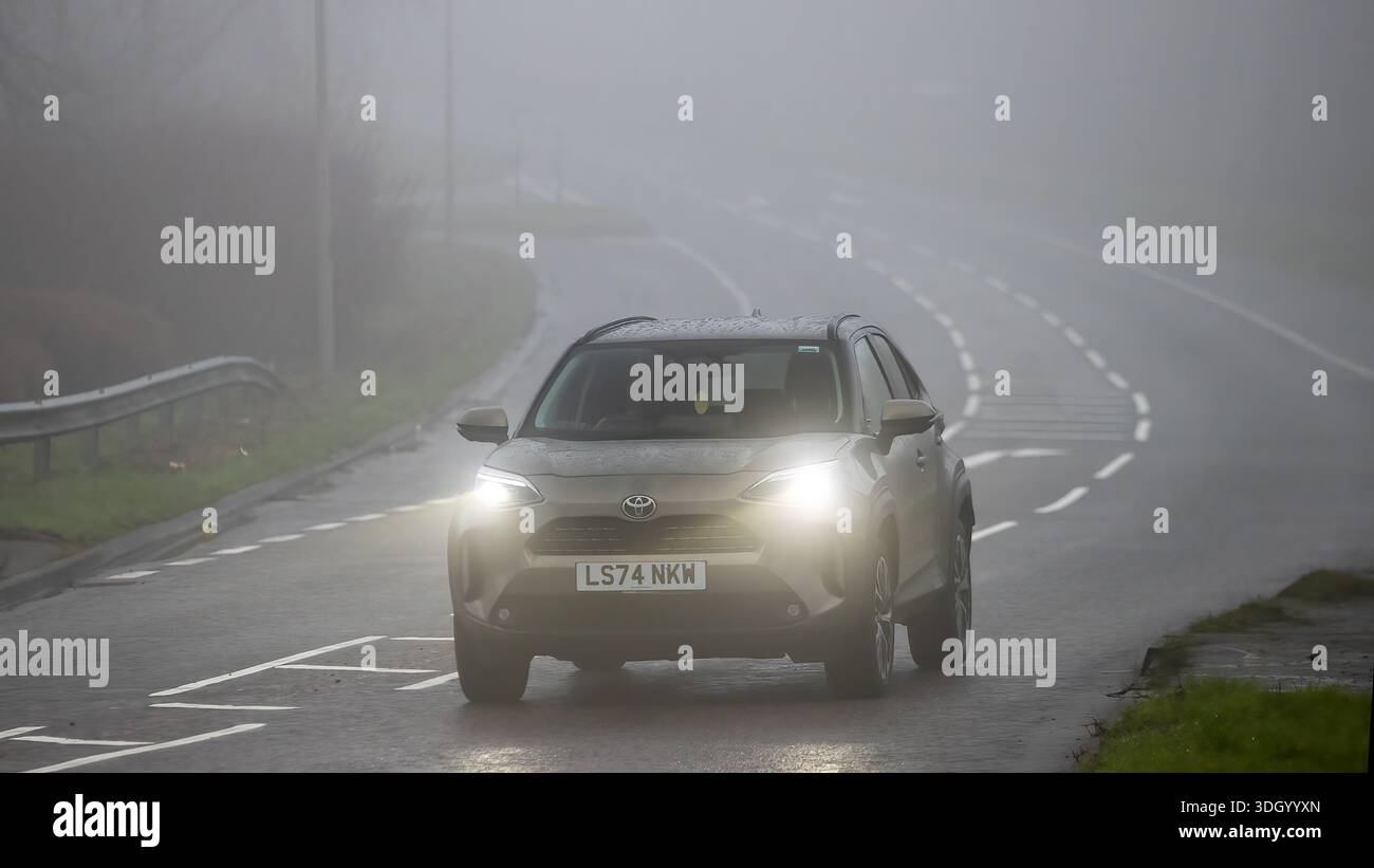 Milton Keynes,Bucks,UK - Jan 18th 2026:  2024 Toyota Yaris hybrid electric SUV car driving on a British road on a damp,foggy morning. Stock Photo
