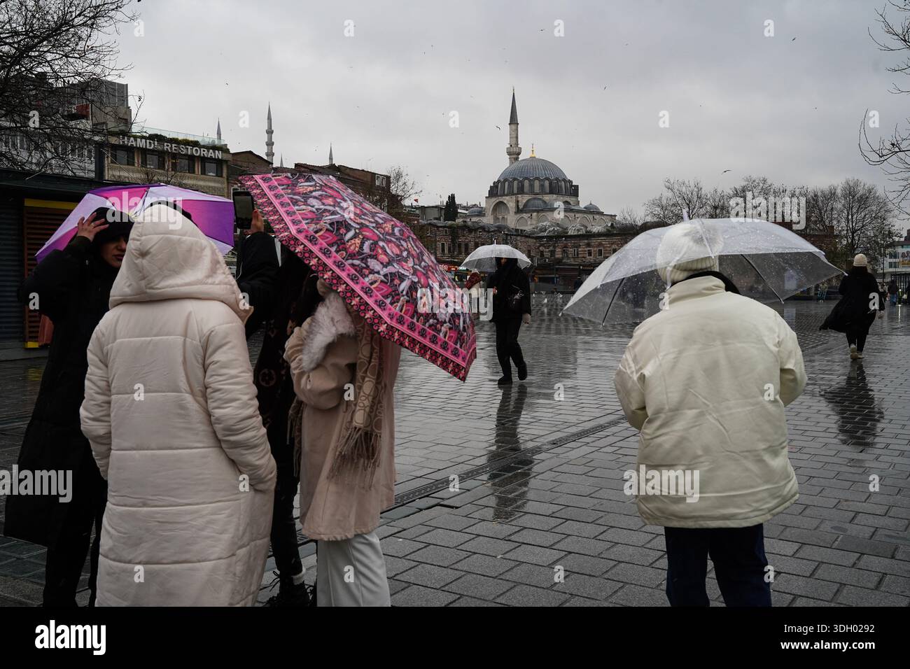 Rustem Stand Istanbul, Turkey. 18th Jan, 2026. People with umbrellas, stand in front ...