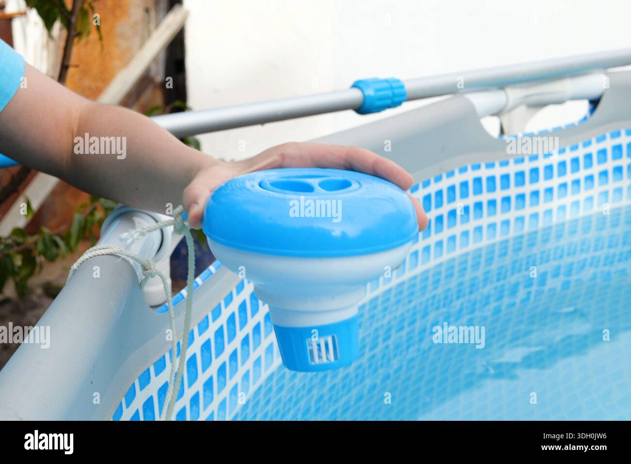 Pool Chloo Worker hands isinfection and chlorination of water in the pool ...