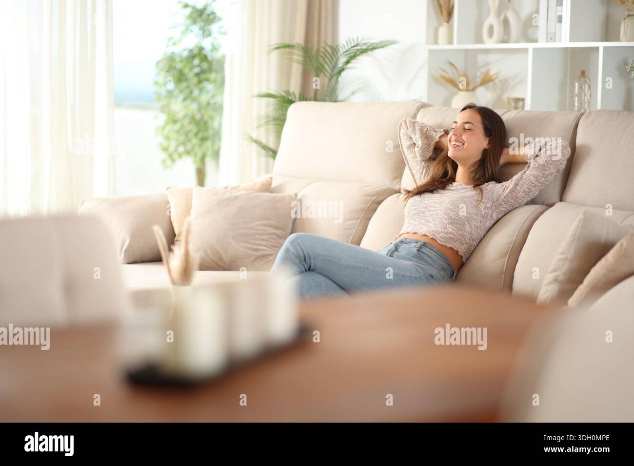Woman relaxing sitting on a couch at home Stock Photo