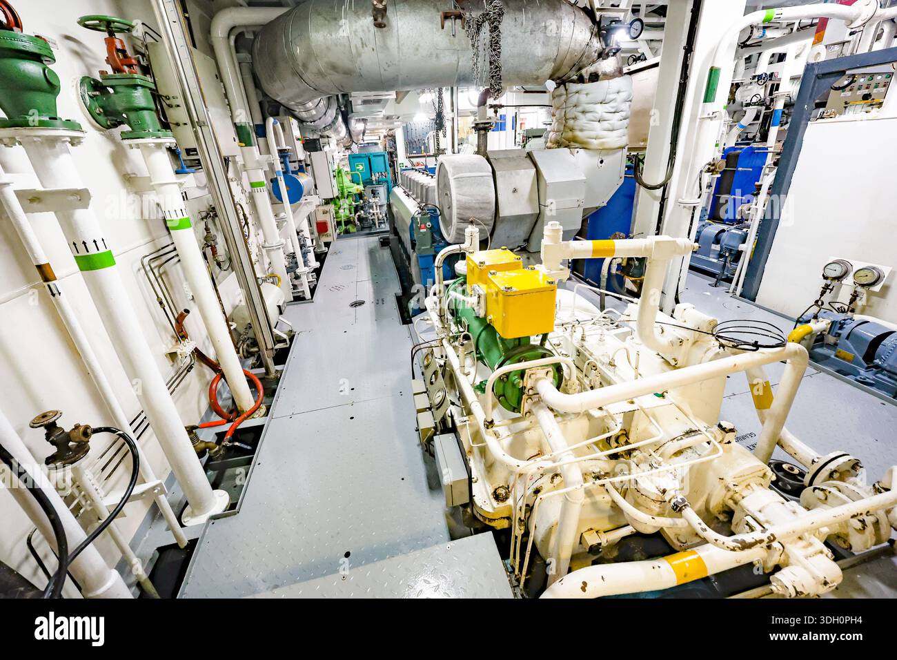 Large marine diesel engine with pumps and pipelines inside ship engine ...
