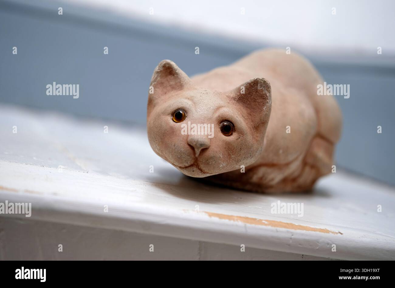 crouching clay cat on stair landing, norfolk, england Stock Photo