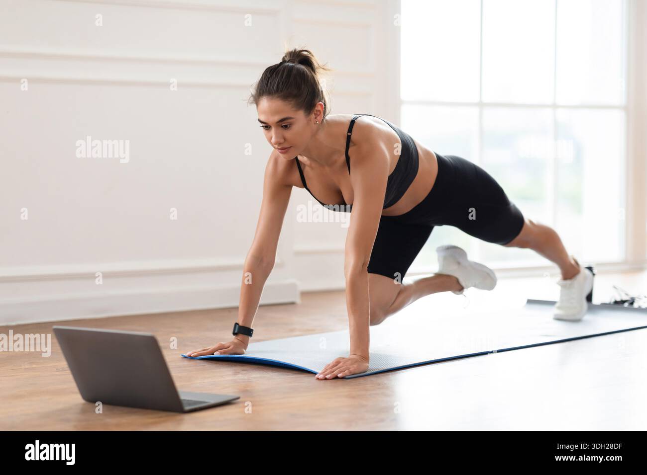 Focused Woman Doing Cross Body Mountain Climbers Exercise Stock Photo