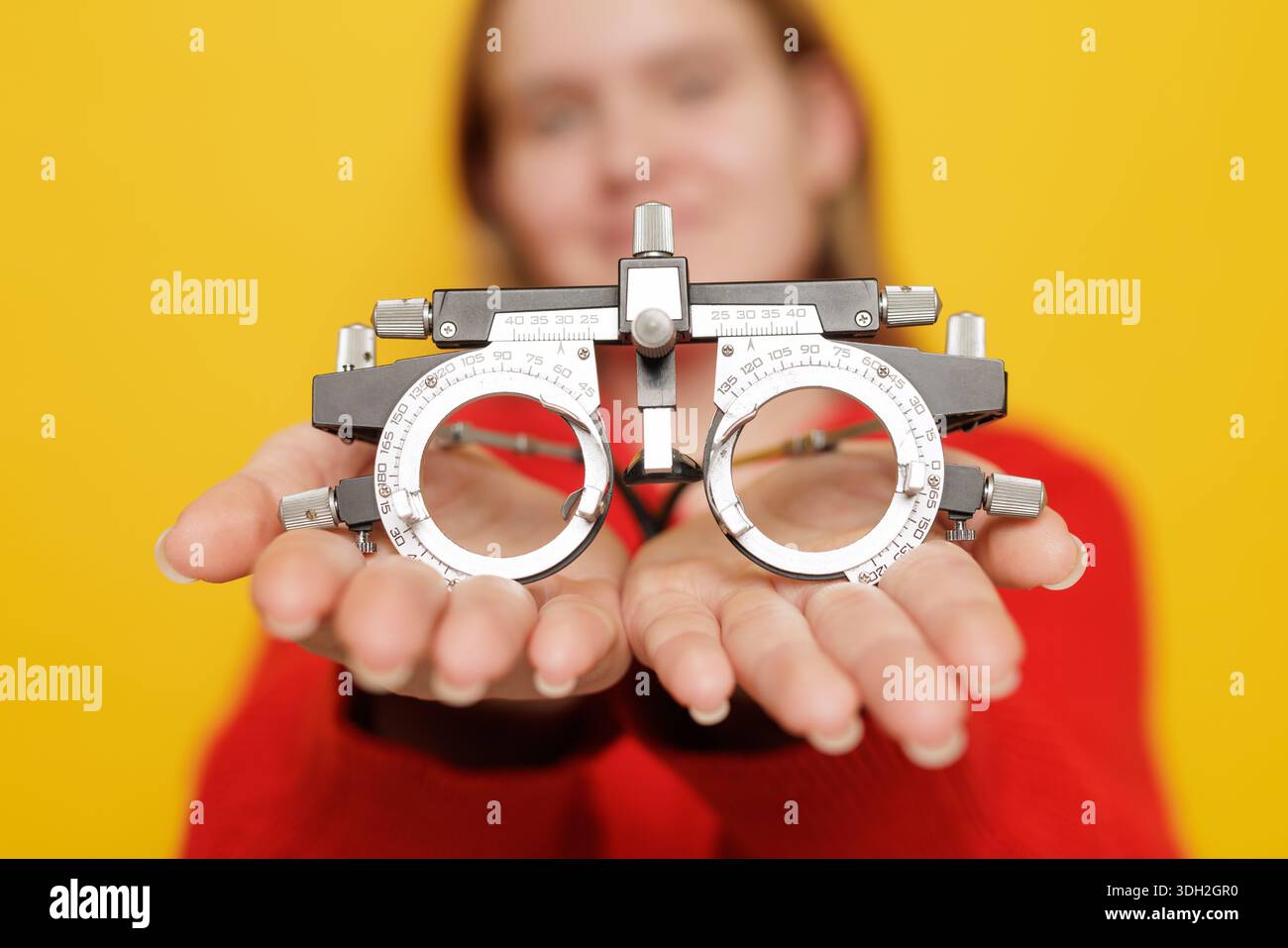 Closeup of trial frame for refraction testing and poor vision correction in ophthalmology optics concept on yellow background Stock Photo