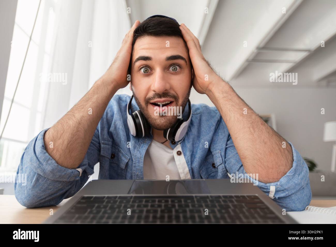 Surprised man having video call using laptop Stock Photo