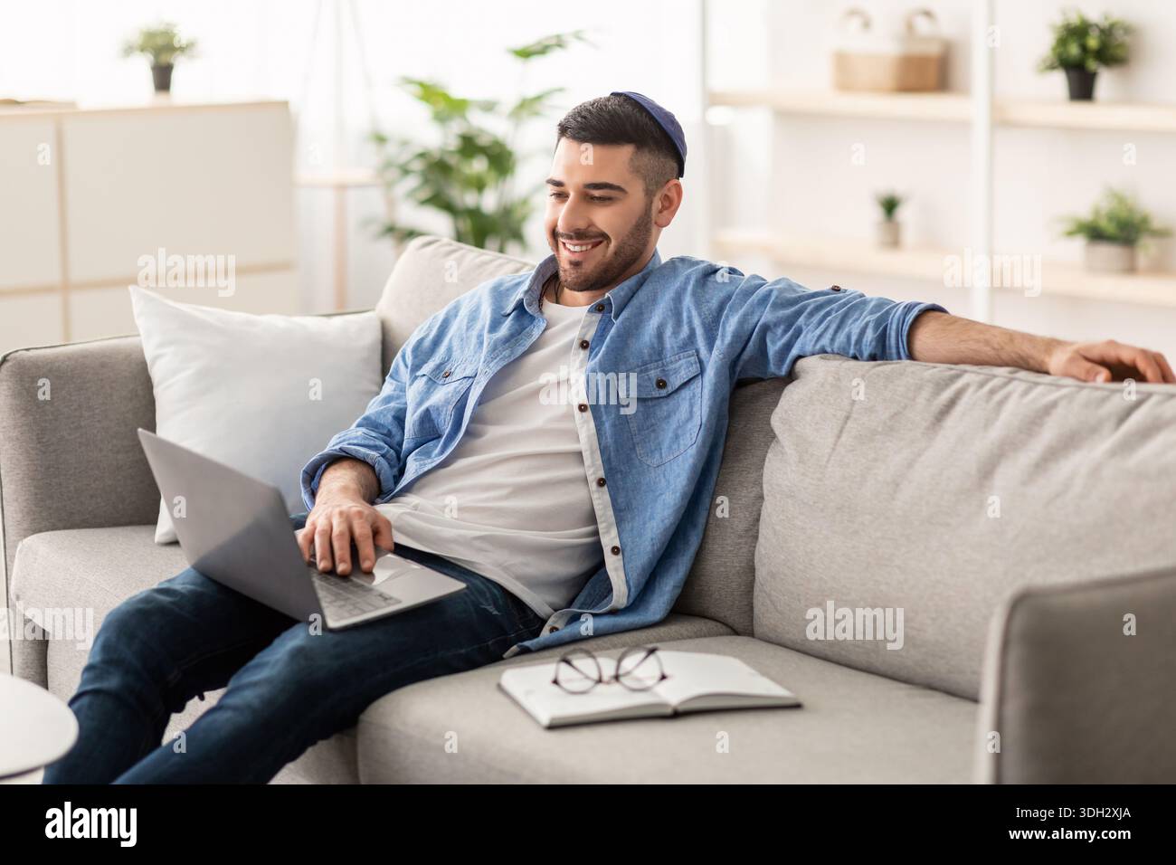 Smiling jewish man watching video on computer Stock Photo