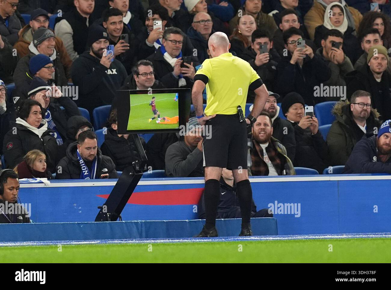 Referee Paul Tierney checks the VAR screen for a penalty decision ...