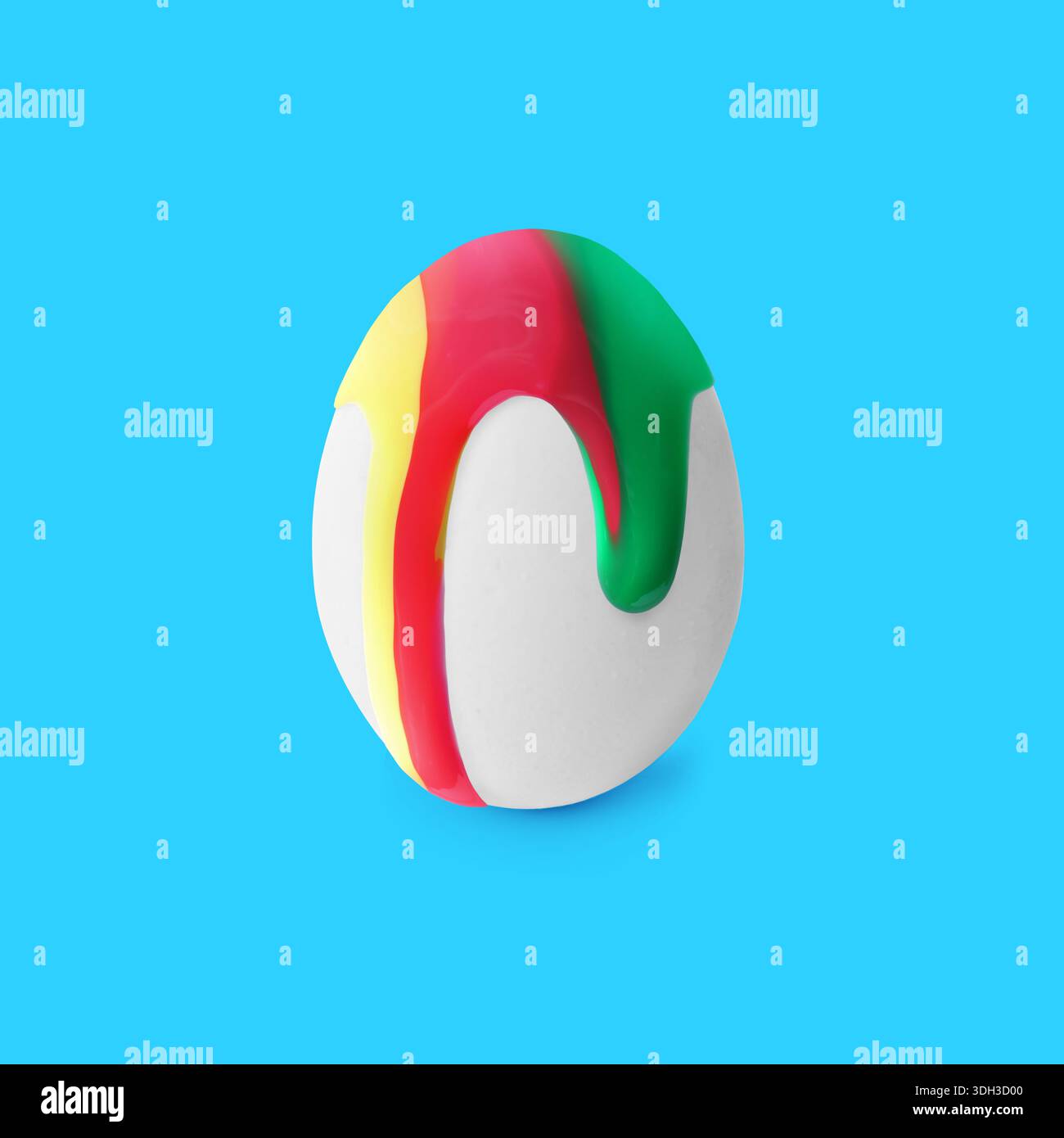 Colorful paint dripping down egg on light blue background. Easter celebration Stock Photo