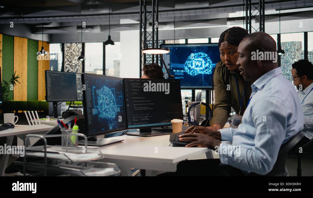Data scientists doing brainstorming in office, using specialized hardware to accelerate complex AI calculations. IT professionals collaborating, managing deep learning datasets systems, camera A Stock Photo