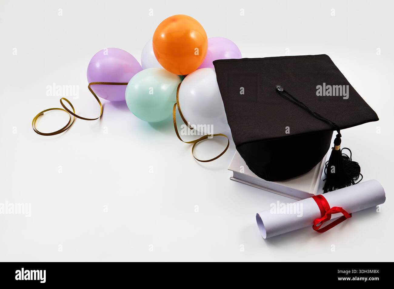 Graduation cap with diploma, books, and celebration balloons Stock ...
