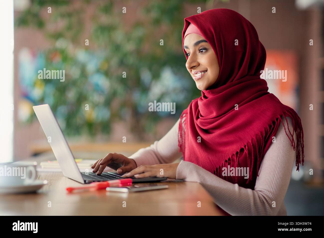 Religious muslim woman typing on laptop keyboard, cafe interior Stock ...