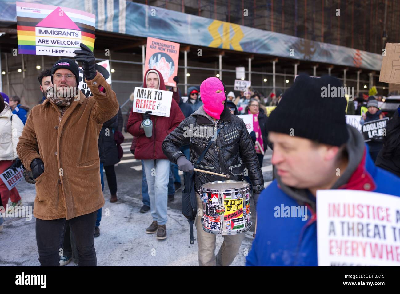A diverse group of protesters march, holding signs advocating for ...