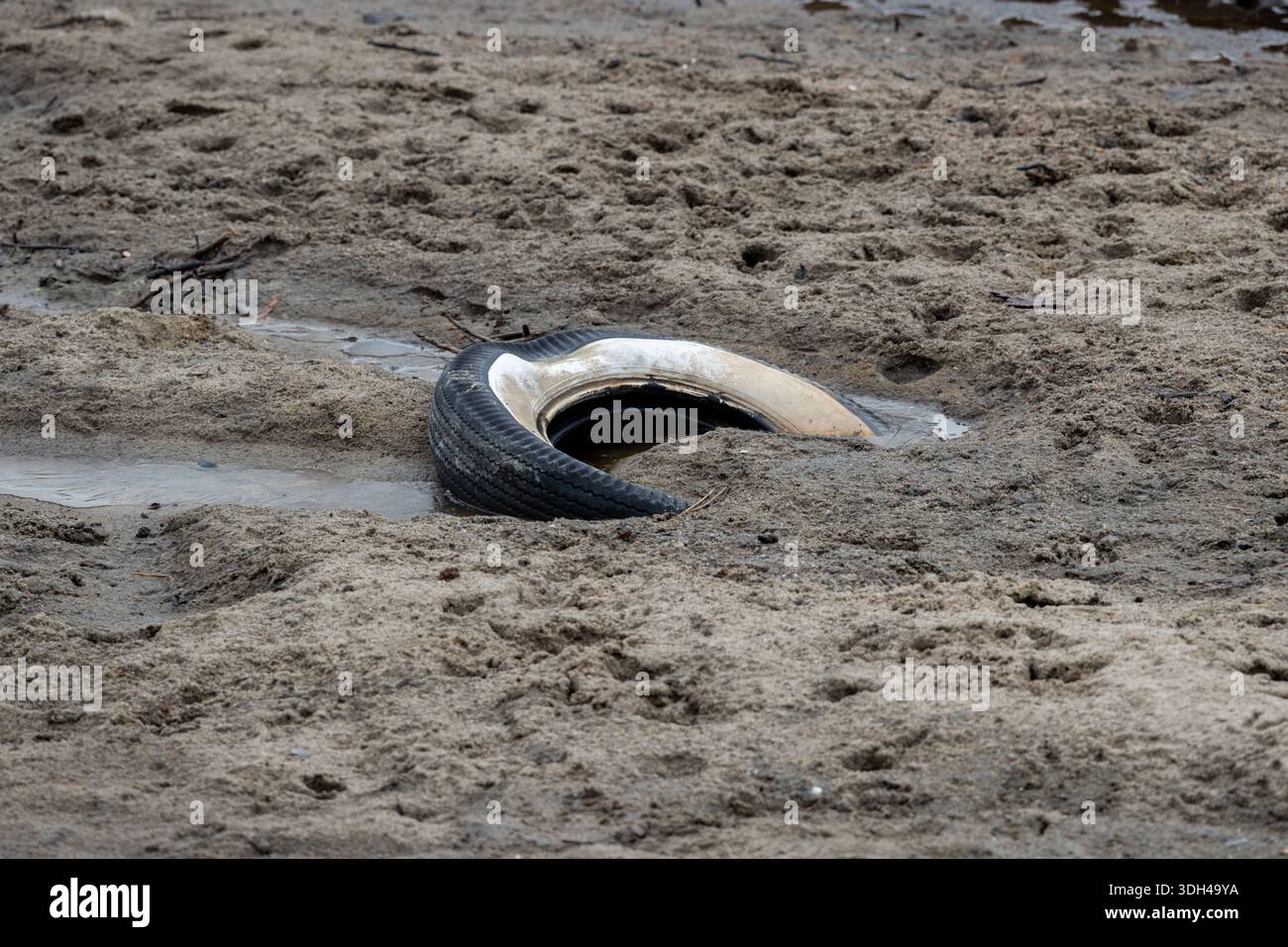 Junk tires, littering a streambed. Stock Photo