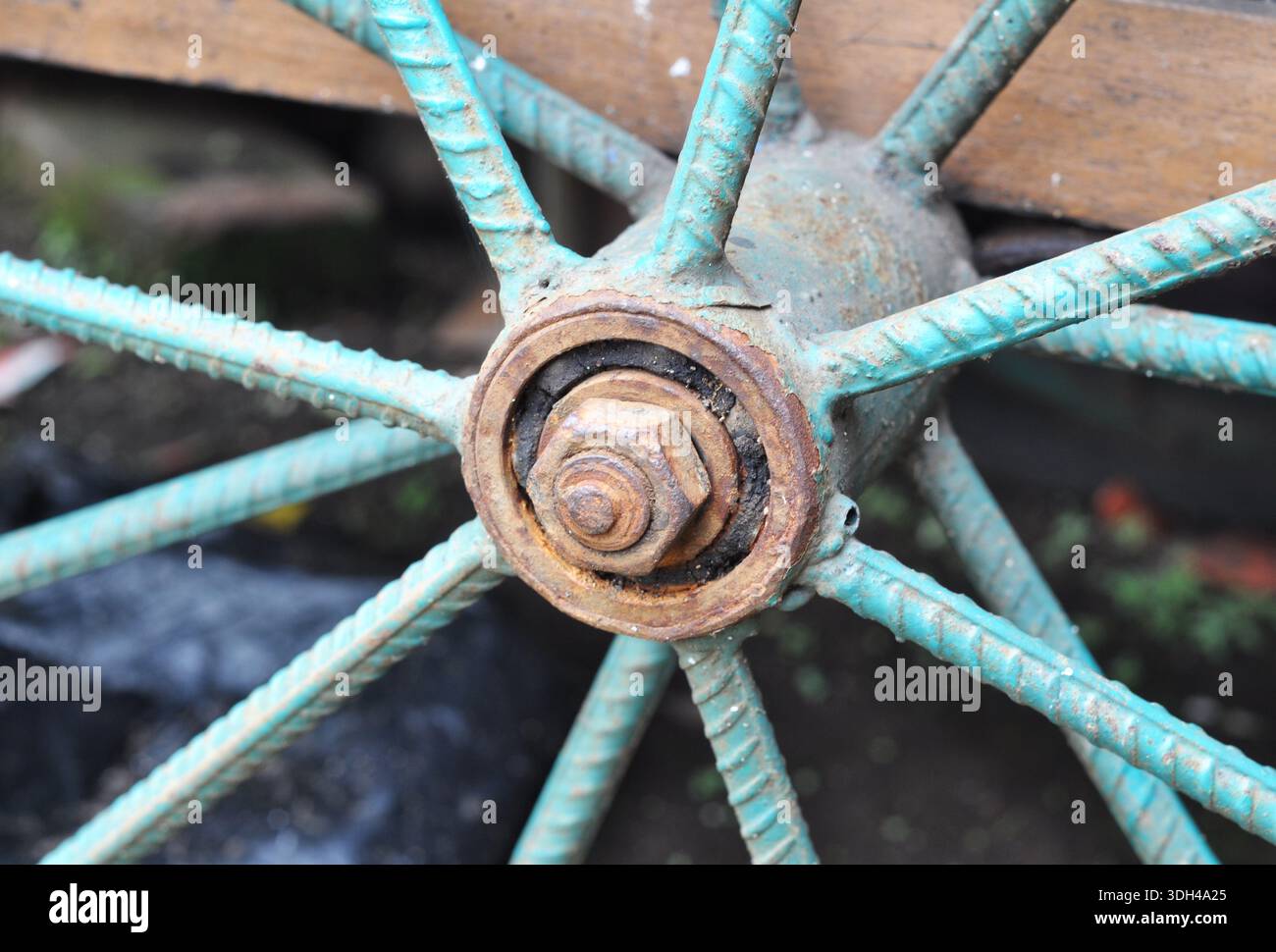 Rusty Metal Wheel Hub with Turquoise Spokes Close-Up Stock Photo