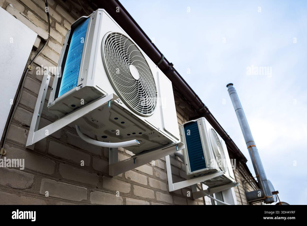 Outdoor two split air conditioning units mounted on siding wall. Stock Photo