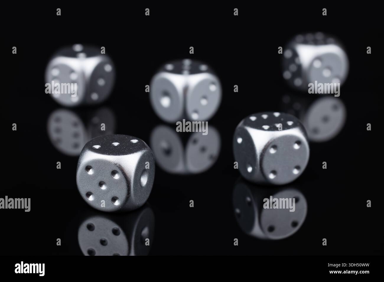 five silver dice view from above on black background. Stock Photo