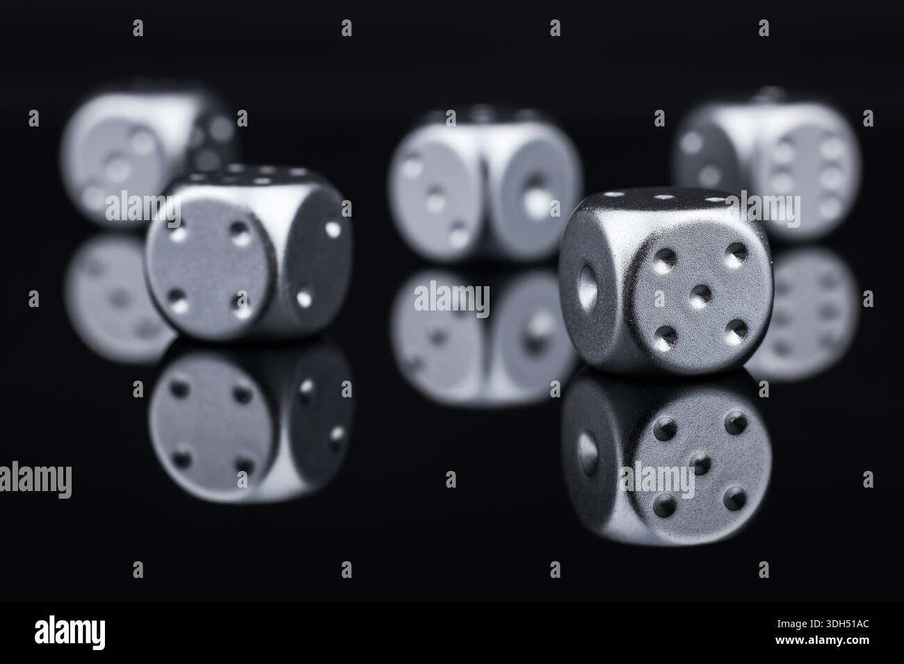 Five silver dice on black background. Stock Photo