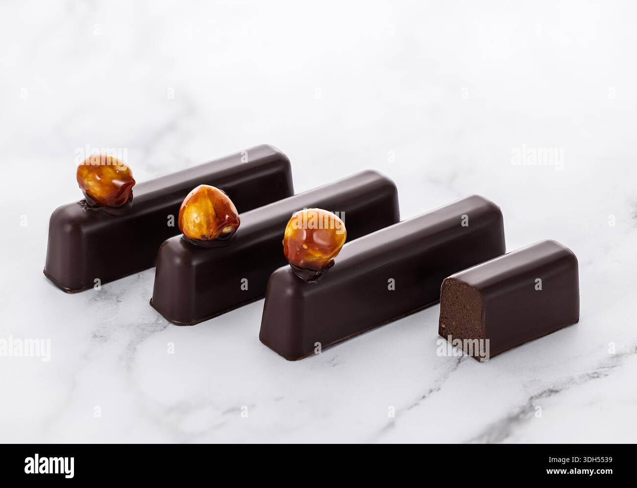 Delicious Chocolate Bars with Hazelnuts on Marble Background Stock Photo