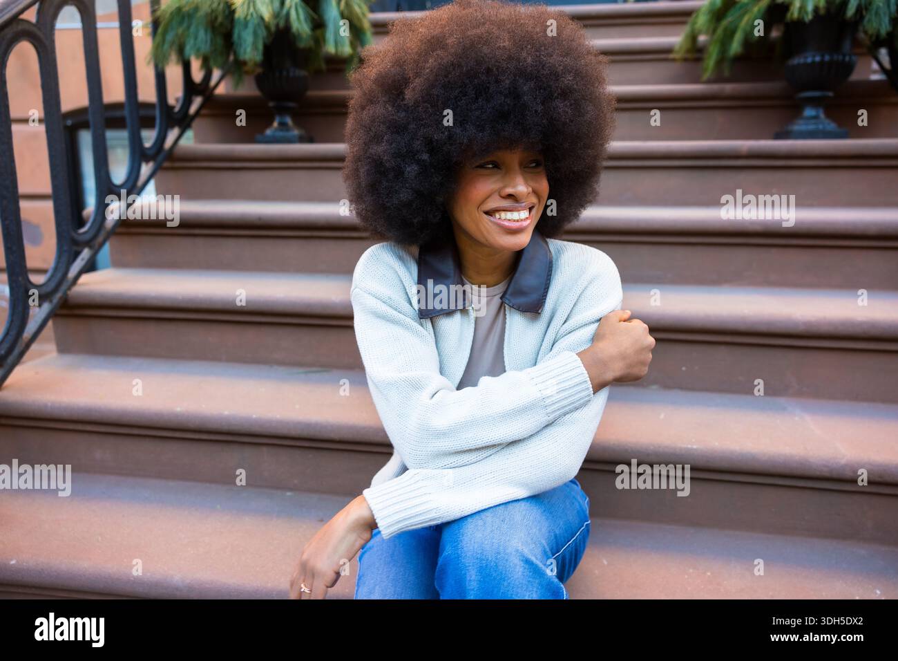 Happy young black woman smiling on brownstone steps Stock Photo - Alamy
