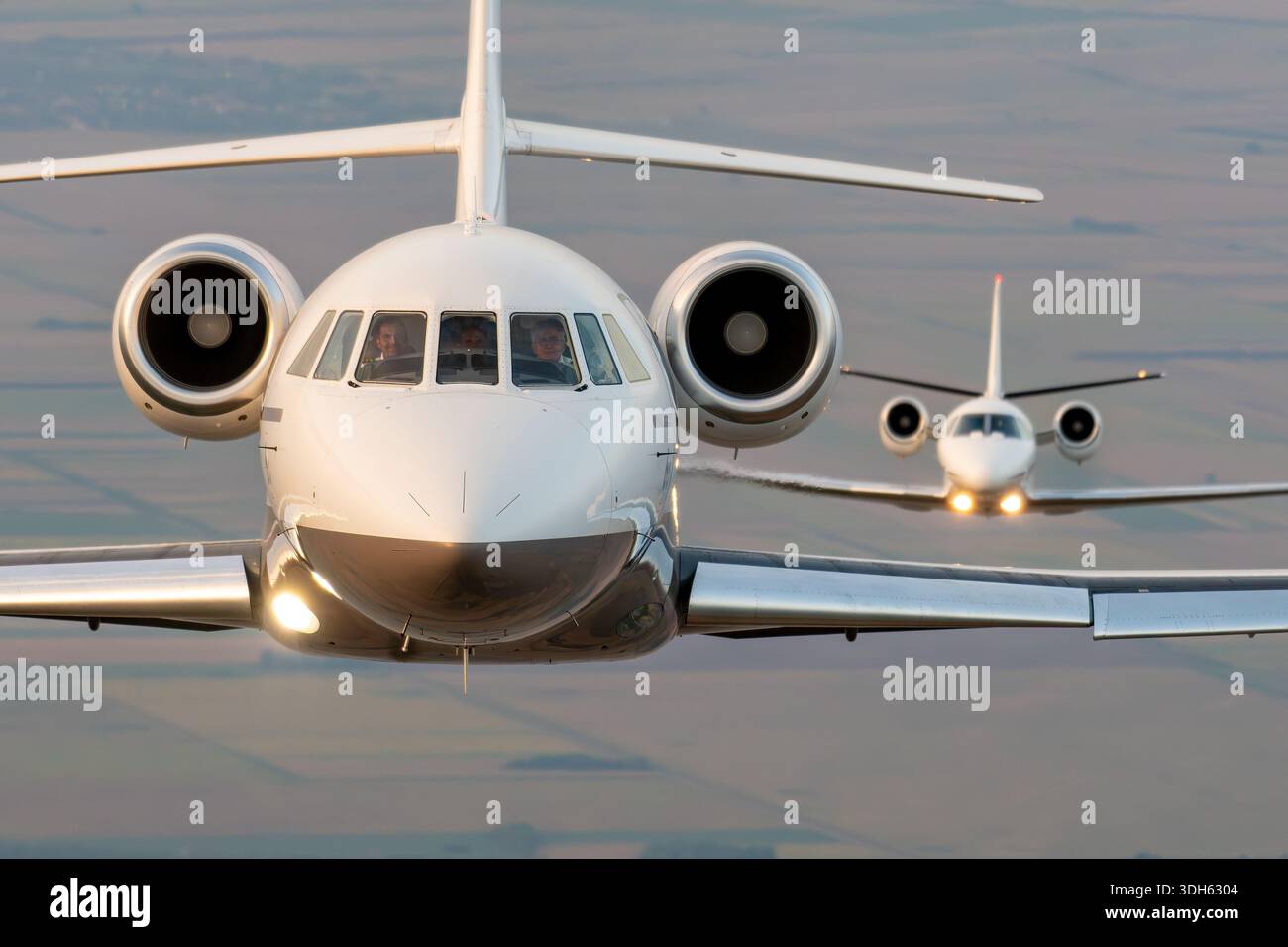 Close up air to air pilot view showing two business jet aircraft flying ...