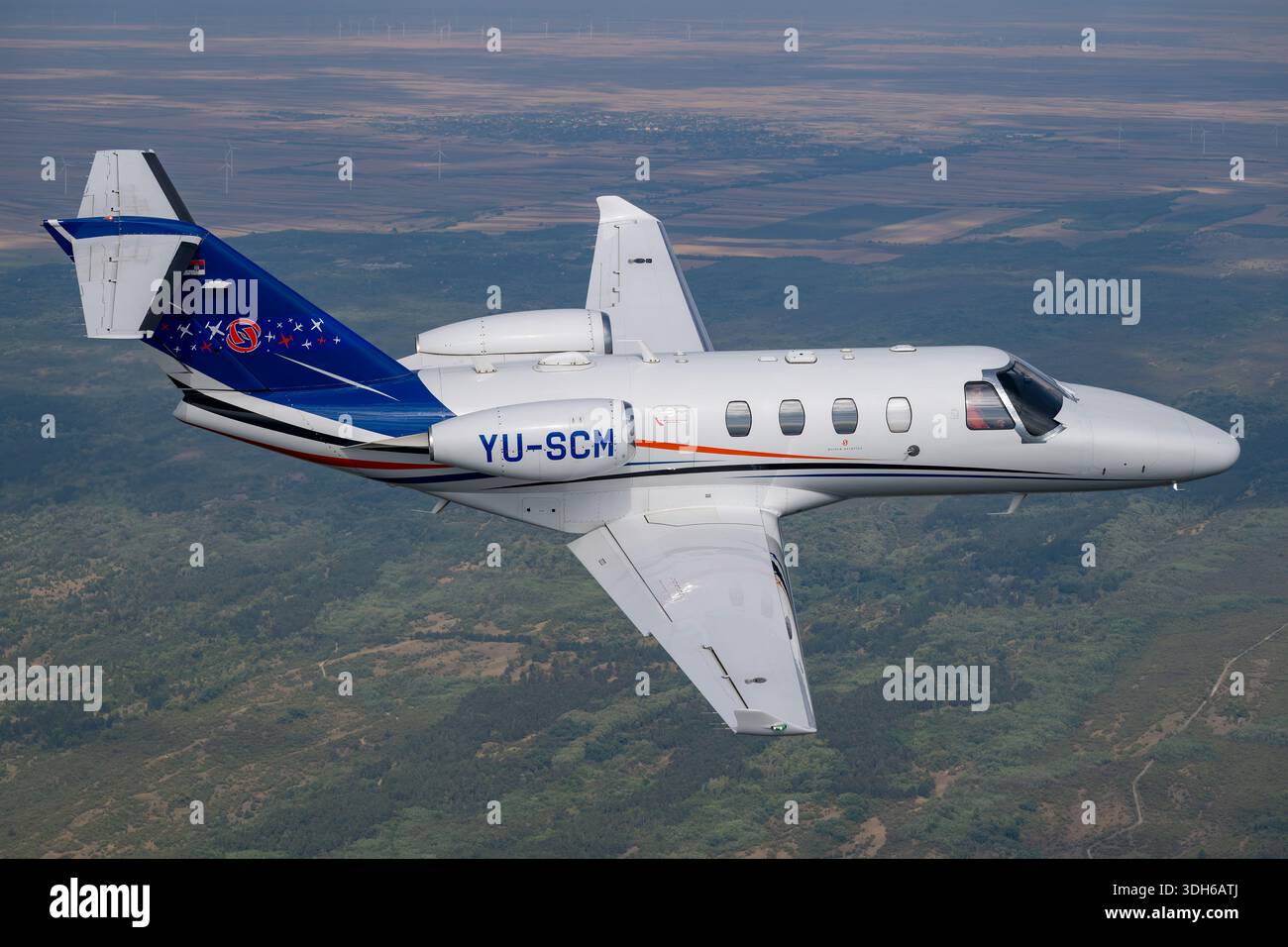 The Cessna 525 CitationJet M2 is a light corporate jet, registration YU-SCM, serial number 525-0918, with two Williams FJ44-1AP turbofan engines. Seating 5–7 passengers, it has a low wing, T-tail, and pressurized cabin. This close-up pilot image from Serbian Airpower 2025 highlights its glass cockpit, aerodynamic design, and flight controls. The M2 is optimized for short-range regional missions, corporate travel, and pilot training with efficient handling and structural integrity. Stock Photo