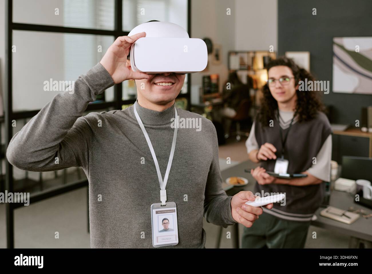 Young Caucasian Man Using Virtual Reality Headset While Smiling Indoors Stock Photo
