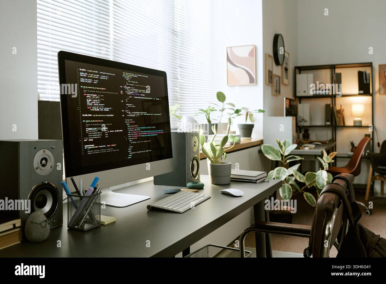 Modern Home Office Desk Featuring Computer Monitor Displaying Programming Code Stock Photo