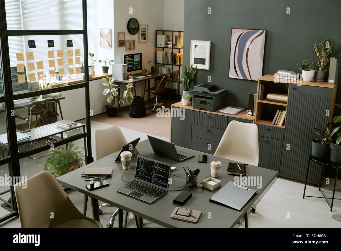 Modern Office Workspace Featuring Laptops and Smartphones on Table Stock Photo