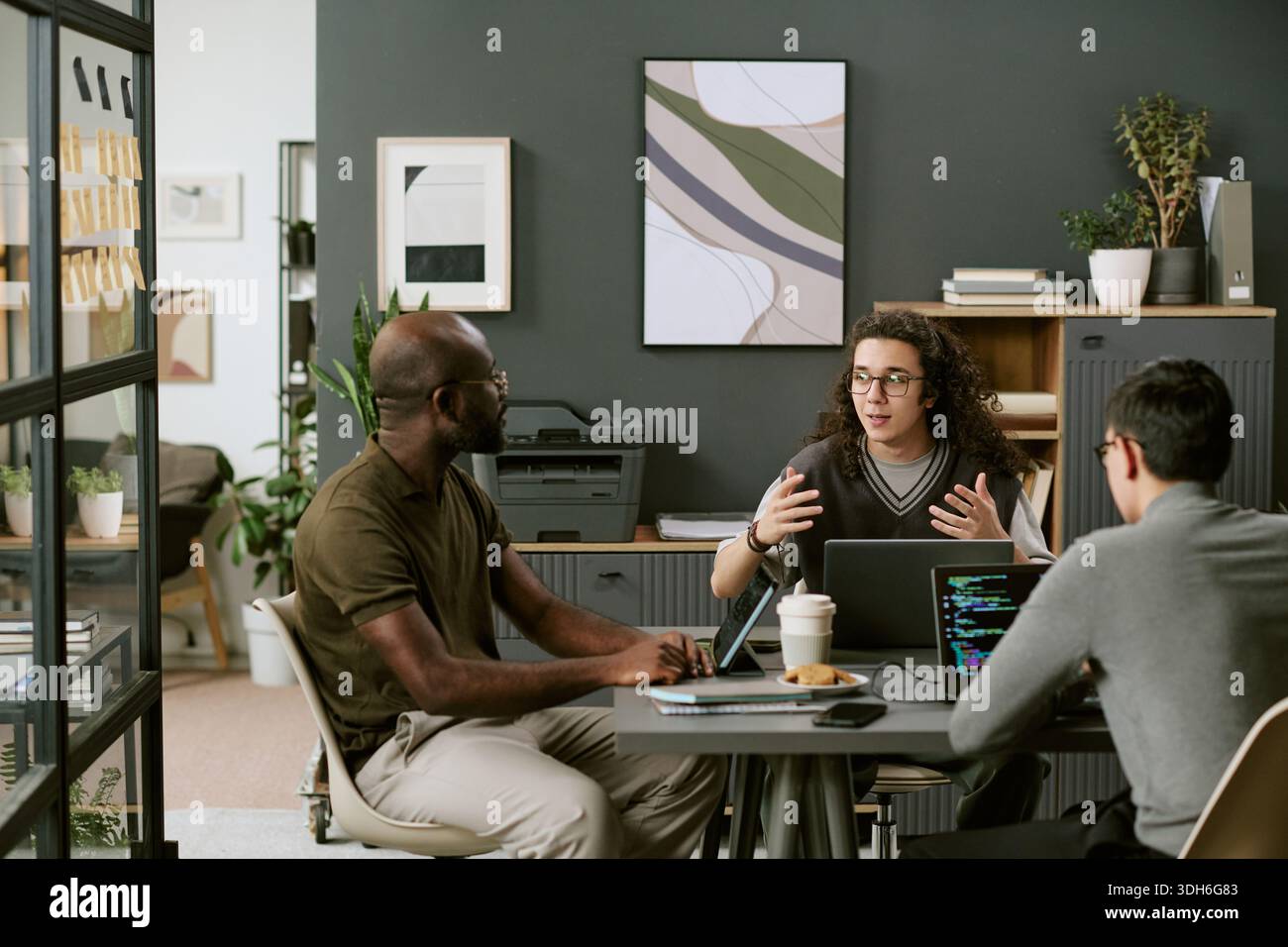 Multiethnic Young Adults Collaborating during Software Development Meeting Stock Photo