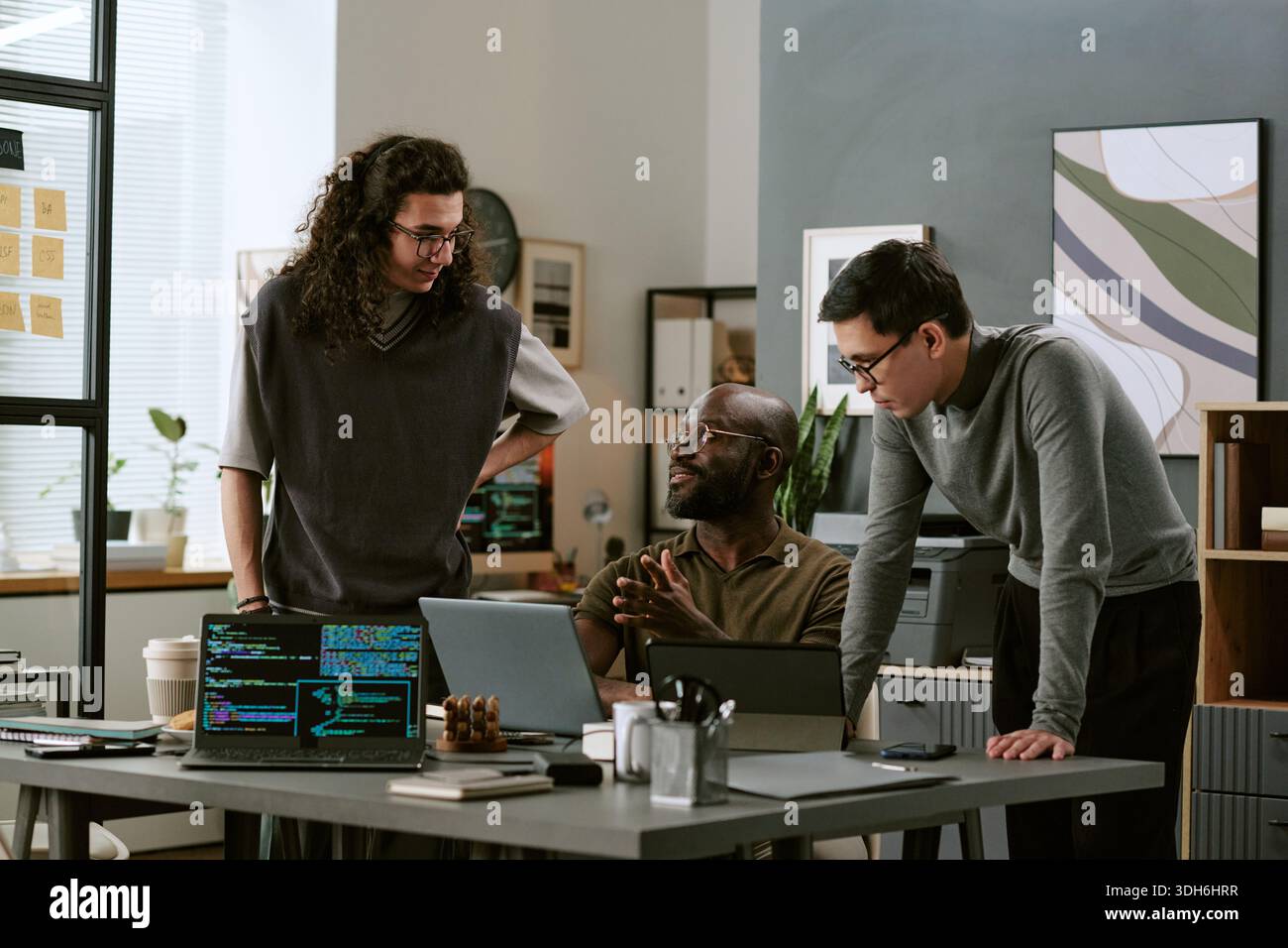 Multiethnic Young Adult Men Collaborating on Software Development Project Stock Photo