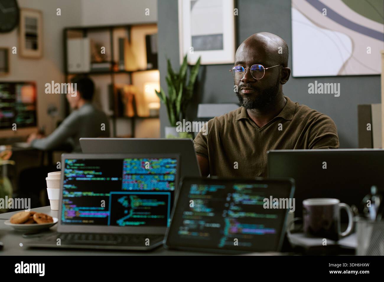 Young Black Man Working on Computer Programming in Modern Office Stock Photo