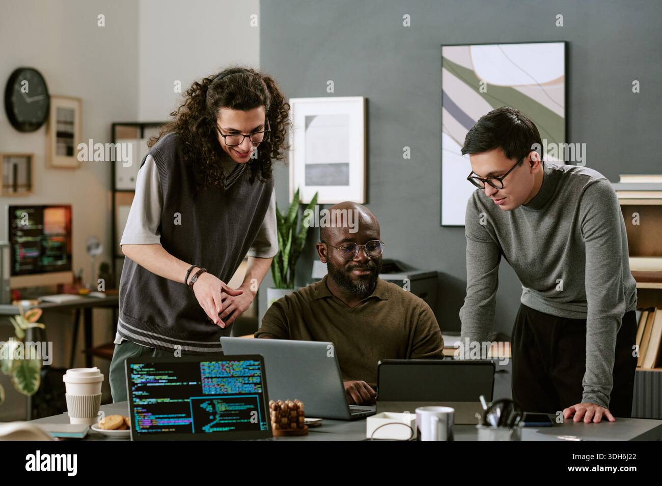 Multiethnic Young Adults Collaborating on Software Development Project Stock Photo