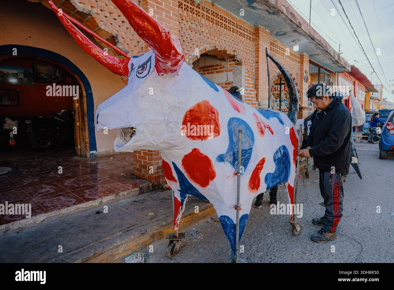 A Mexican man adjusts the wheeled structure of a monumental painted ...