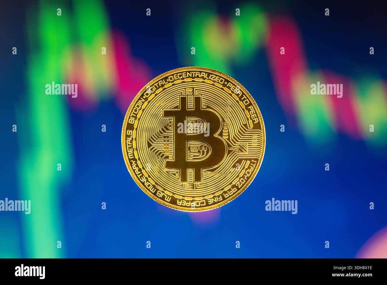 A gold colored bitcoin with the letter B on it. The coin is floating above  a graph of a stock market Stock Photo - Alamy