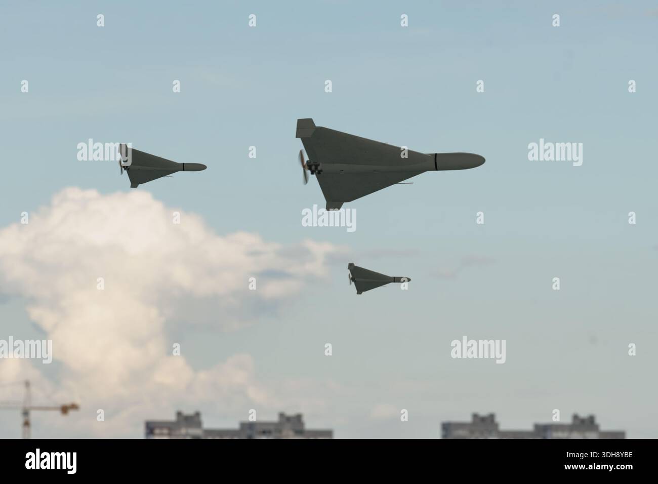 Several military drones flying in formation in sky Stock Photo